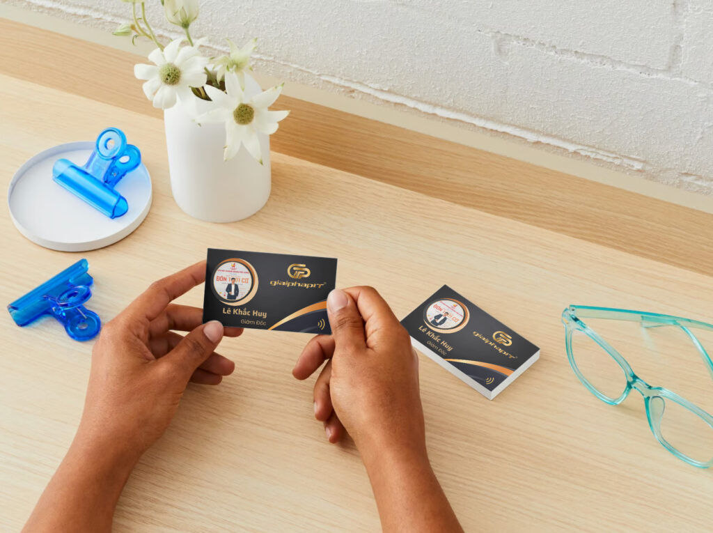 Cầm namecard NFC của doanh nghiệp trên bàn làm việc